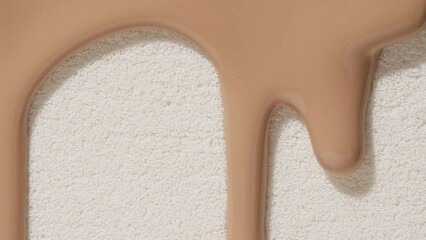 Foundation for face, smear, concealer, cosmetic liquid foundation, or cream beige color smudge flowing down on sponge. Beauty skincare sample. Macro Shot. Close up. High quality 4k footage
