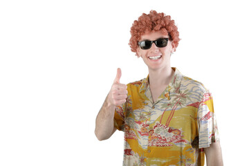 CARNIVAL CONCEPT - Guy with sunglasses and wig wearing a colorful shirt rising thumb up, smiling looking at camera. 18-20 years old, white boy. Isolated on white background.