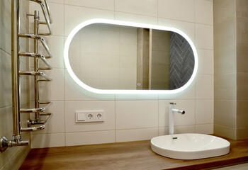 Large oval mirror and overhead washbasin in the bathroom - 484474317