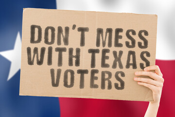 The phrase " Don’t mess with Texas voters " on a banner in men's hand with blurred Texans flag on the background. Fraud. Laws. Voice. Survey. News. Nation. Duty. Citizen. Bulletin. System. Texan