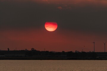 Beautiful lagoon landscape background with sun setting in the clouds