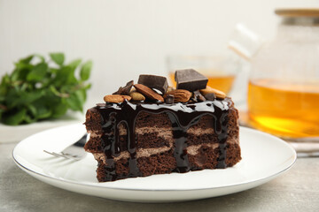Piece of tasty homemade chocolate cake with nuts on grey table, closeup