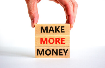 Make more money symbol. Concept words Make more money on blocks on beautiful white table white background. Businessman hand. Business and make more money concept. Copy space.