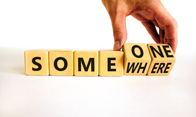 Someone somewhere symbol. Businessman turns wooden cubes and changes the concept word Someone to Somewhere. Beautiful white table, white background, copy space. Business, someone somewhere concept.