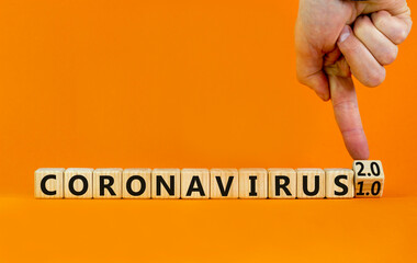 Covid-19 coronavirus 2.0 symbol. Doctor turns cubes and changes words coronavirus 1.0 to coronavirus 2.0. Beautiful orange background copy space. Medical Covid-19 coronavirus 1.0 or 2.0 concept.