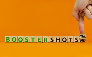 Covid-19 booster vaccine shots yes or no symbol. Doctor turns cubes changes words booster shots no to booster shots yes. Beautiful orange background copy space. Covid-19 booster vaccine shot concept.