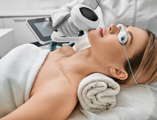 Photorejuvenation, rosacea treatment, removing brown spots and vascular mesh. Cosmetologist using...