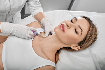 Neck skin rejuvenation and contouring with beauty injections. Smoothing female neck skin with...