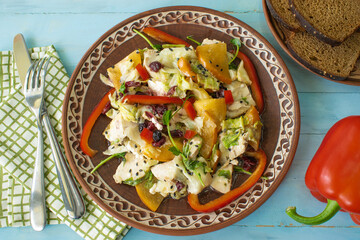 Salad with chicken and cheese, with herbs, persimmons, bell peppers. The concept of diet food. Delicious salad in bowl on wooden background, top view, banner
