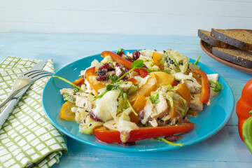 Salad with chicken and cheese, with herbs, persimmons, bell peppers. The concept of diet food. Delicious salad in a bowl on a wooden background, selective focus.
