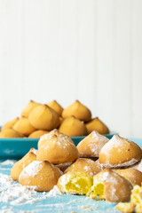 Shortbread cookies consisting of butter, flour, and jam filling, view of baked sweet cookies and a glass of milk on a wooden background, selective focus
