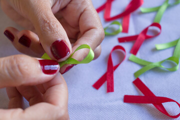 Cintas de colores, cintas para campañas de lucha contra el cáncer y el SIDA. Manos preparando...