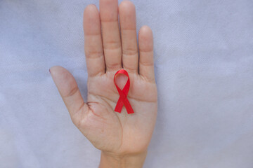 Cintas de colores, cintas para campañas de lucha contra el cáncer y el SIDA. Manos preparando cintas rojas y verdes. Campaña roja de concientización sobre el VIH