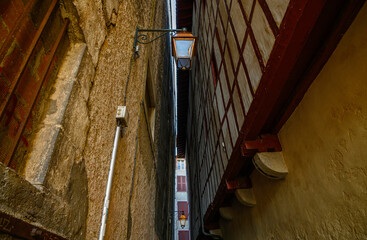 view of a very, very narrow street, le des Basques, in Bayonnes apartment buildings almost side by...