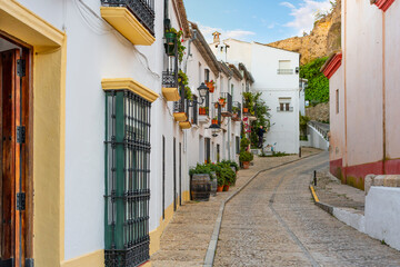 A picturesque, colorful traditional street in the White Village of Zahara de la Sierra in the Andalusian region of Southern, Spain.