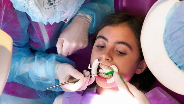 Young girl in the dentist studio. Dental appliance insertion