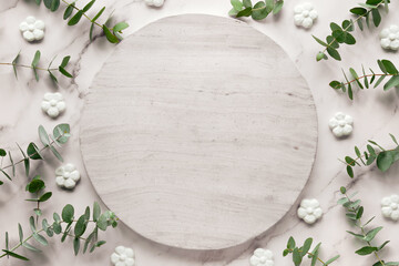 Wintertime mockup with text space on round, circle stone board. Fresh eucalyptus leaves and twigs....