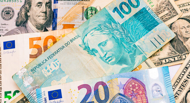Real, D&oacute;lar e Euro. C&eacute;dulas banc&aacute;rias em fotografia macro. Conceito de c&acirc;mbio, neg&oacute;cios internacionais e economia brasileira.