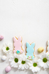 Easter bunny, egg and flowers light background top view