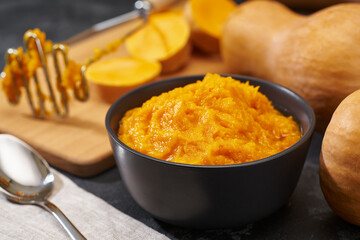 Making pumpkin puree on a on black table, selective focus.