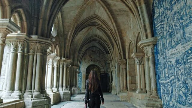 Young fashionable tourist girl exploring Portuguese architecture. A tourist traveling in Porto, Portugal enjoying Medieval Palace structure.