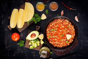 Chili con carne in bowl on dark background. Mexican cuisine. Top view, above