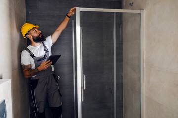 A handyman checking on the shower if it is done perfectly. 