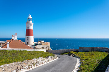 The red and white lighthouse at Europa Point, also known as Trinity Lighthouse near the Rock of Gibraltar, in the UK Territory, along the Mediterranean Sea.