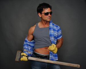 The sexy construction man poses for the photo. - obrazy, fototapety, plakaty