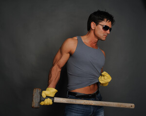The sexy construction man poses for the photo. - obrazy, fototapety, plakaty