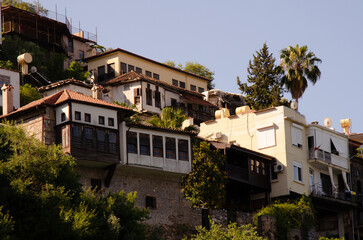 Fototapeta na wymiar Landscapes of Turkish resort town. Old houses with palm trees are located on hillside. Holidays in Turkey with copy space.
