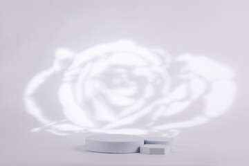 Gray background with a rose white shape behind for product commercial. Made out of geometric forms