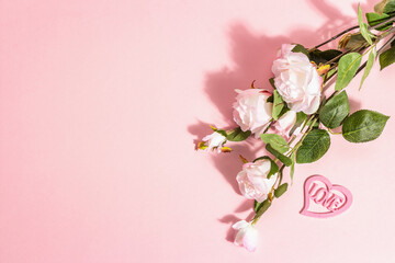 Blooming roses on a branch, a heart with the word "Love". Valentines Day or Wedding concept