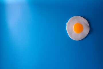 Fried egg is minimal. Fried egg isolate on a blue background.