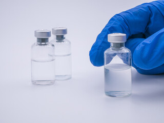 Hand holding vaccine bottle isolated on white background