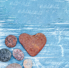 A pyramid of sea stones on a blue background. Sea pebbles and seashells on the table.