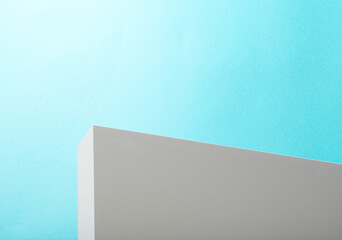 White wall or 3d platform against blue background. Sunny bright outdoors scene with white surface or wall. 