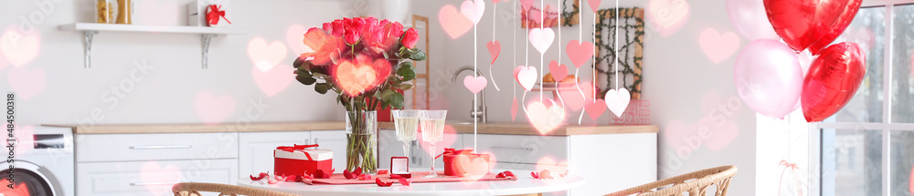 Sticker Engagement ring with bouquet of flowers, glasses of champagne and gifts on dining table in kitchen