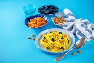 Turmeric basmati rice with dried apricots and prunes and almonds in a plate