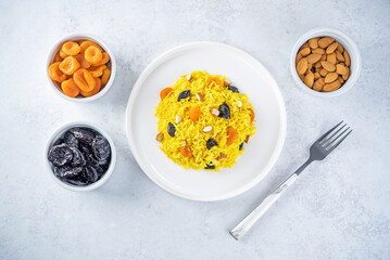 Turmeric basmati rice with dried apricots and prunes and almonds in a plate