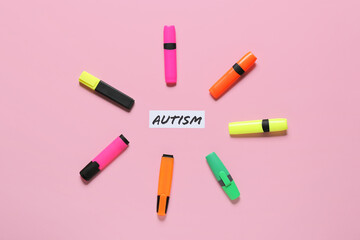 Colorful markers and word AUTISM on color background