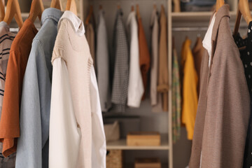 Wardrobe closet with different stylish clothes indoors, closeup