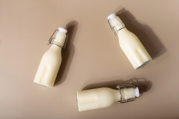 Kefir, buttermilk or yogurt in glass. kefir on a beige background in a bottle