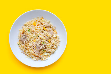 Fried rice in white plate on yellow background.