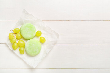 Delicious mochi and grape on white wooden background