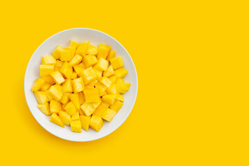 Tropical fruit, Mango cube slices in white plate on yellow background.