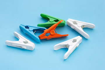 Plastic clothespin on blue background.
