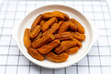 Sun-dried bananas on white background.