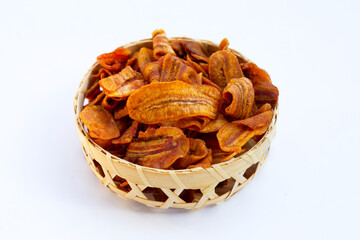 Banana slice chips in bamboo basket on white background.