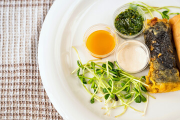 Plate with sprouted vegetable, 3 bowl with sauce, vietnamese roll with seaweed.